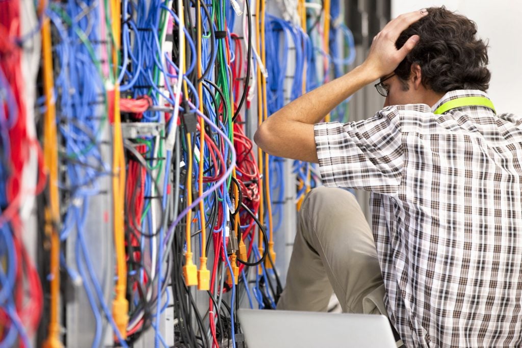 Frustrated technician working in Server room of data center