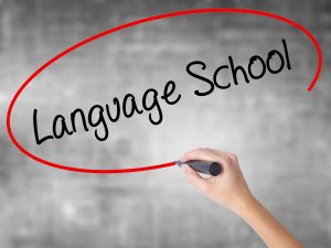 Woman Hand Writing Language School with black marker
