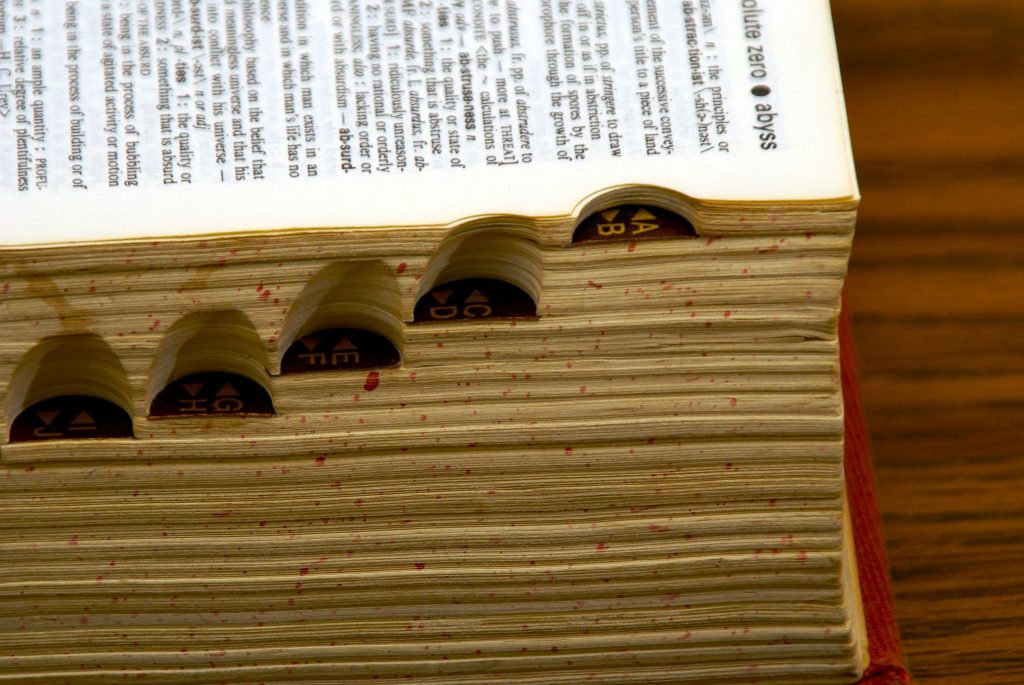 old dictionary with page open, showing side tabs