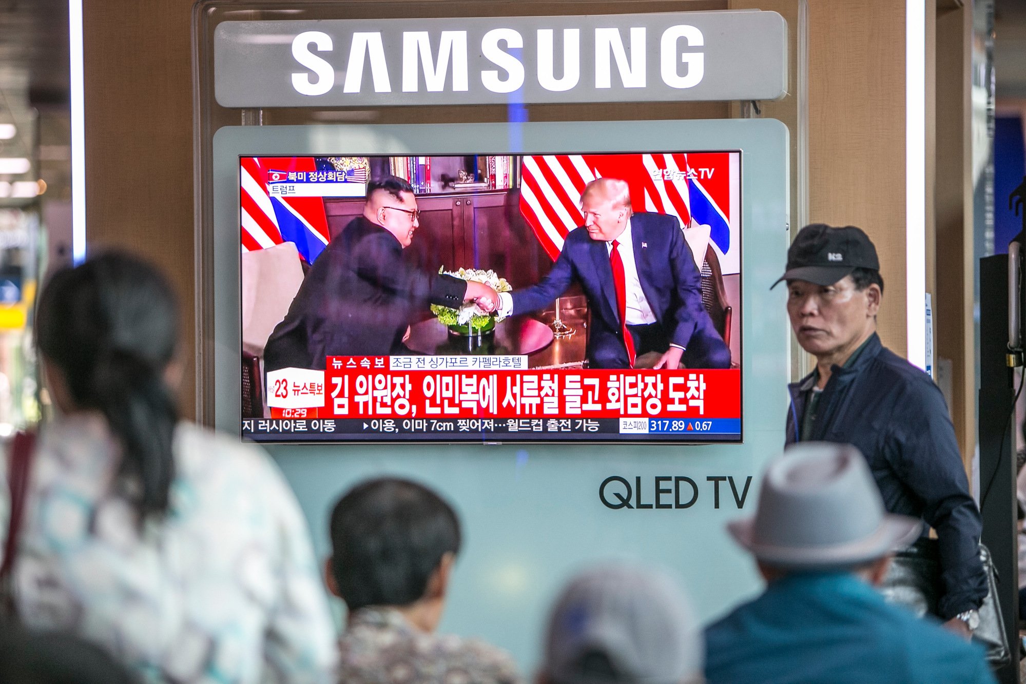 trump-kim meeting being watched by civilians on television