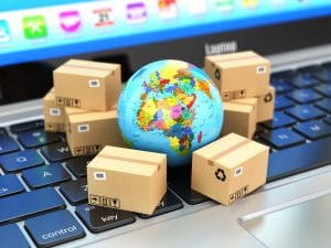 businesses trading globally represented by small boxes around a miniature globe on top of a keyboard