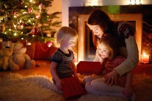 mother and her daughters looking at an open christmas gift