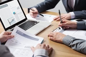 Business professionals working together at office desk over a financial translation document