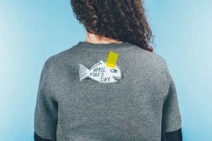April fools Day written on a paper fish tapped at the back of a lady