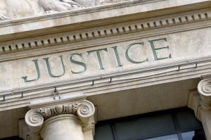 Etched Justice sign on a Law Courts building
