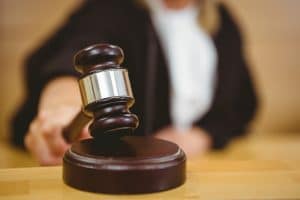 legal interpreting - judge holding a wooden mallet on a wooden gavel