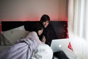 couple in bed using laptop